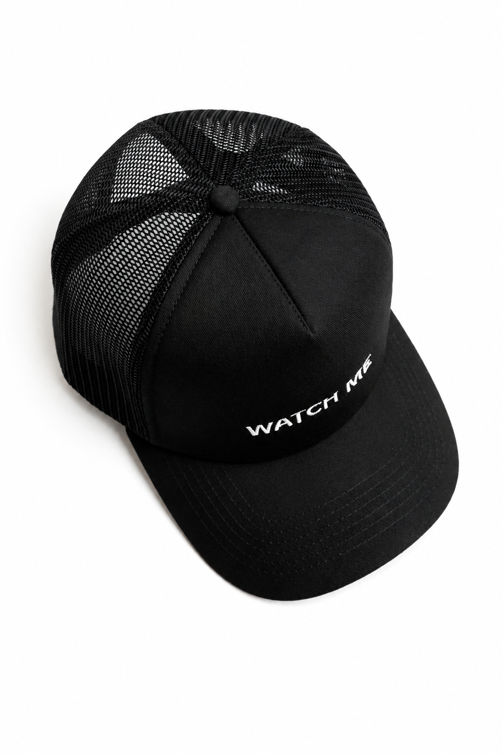 A black trucker hat with a black mesh back and white embroidered text reading 'WATCH ME' on the front panel, shown on a plain white background